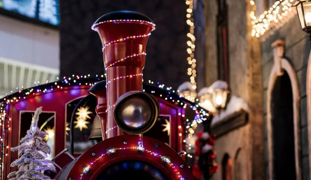 Travelling with AWC this Christmas: The top of a steam train displayed with Christmas decorations.