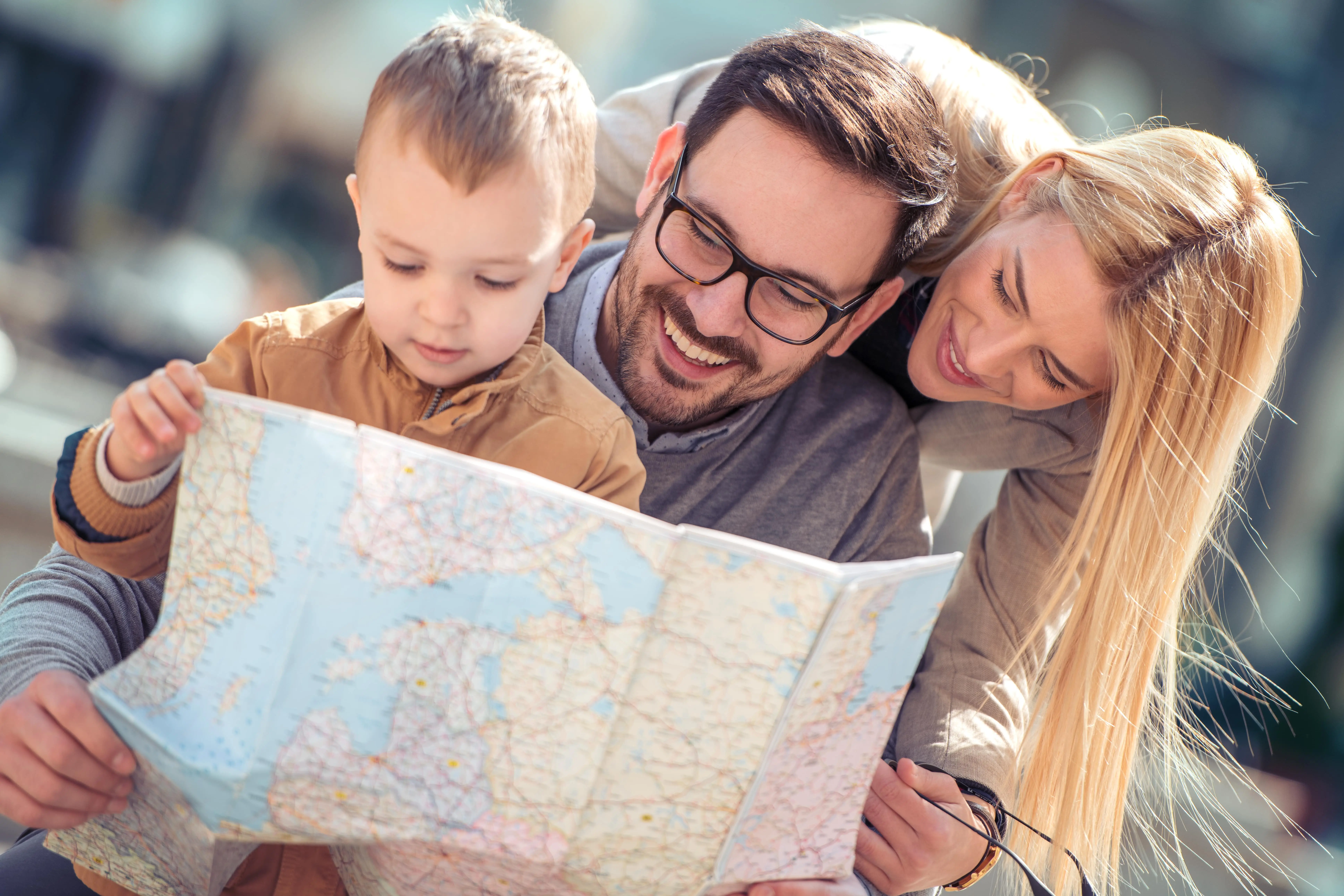 Happy family of tourists looking for destination with city map