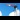 A traditional railway semaphore signal with a red and white arm in the stop position, set against a bright blue sky with scattered clouds