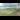 Railway Pioneers: A photo from the window of a train, looking out to see it curving around a bend, with a lush, green field to the left.