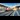 Rail Advertising: A sleek high-speed train with a modern white and red design racing through a railway station