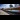 Avanti West Coast: A train speeds through an empty station as grey clouds hang in the sky.