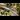 Model Trains: A model railway depicting a green train passing by small trees.