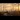 Train Fuel: A series of electricity pylons powering train tracks with the background of a setting sun.