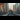 Future Trains: In the distance, a train comes towards the camera on an overground railway line, as the sun sets on a city in the background. Future Trains: An engineer peers under a stationary train as they contemplate it.