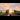 Eco-Friendly Transportation: A railway engineer inspects rail tracks to a backdrop of a setting sun.