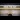 A view of somebody's feet on the platform of an underground station underneath the words ‘Mind the Gap’
