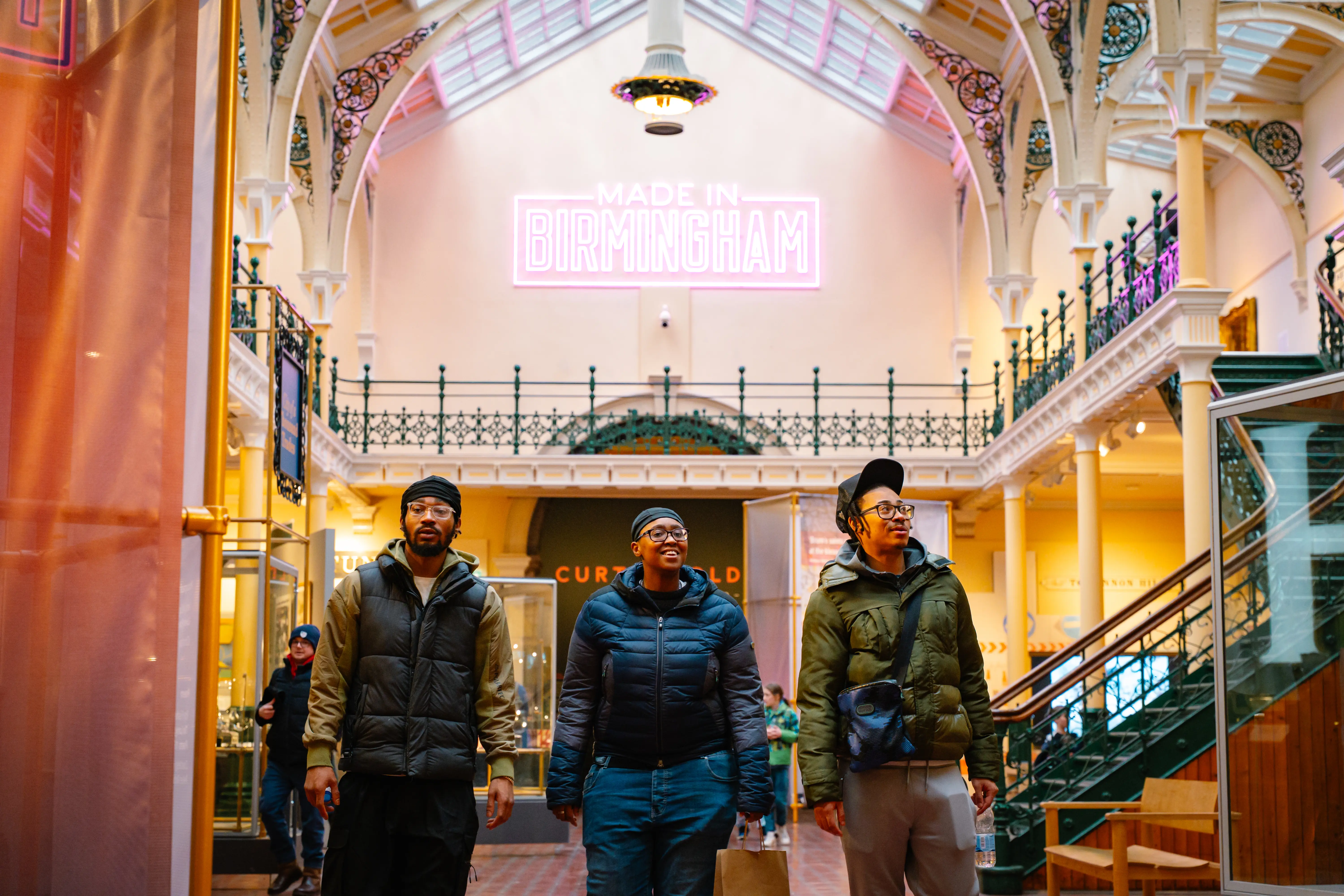 Three friends walking through the Industrial Gallery of the Birmingham Museum & Art Gallery.