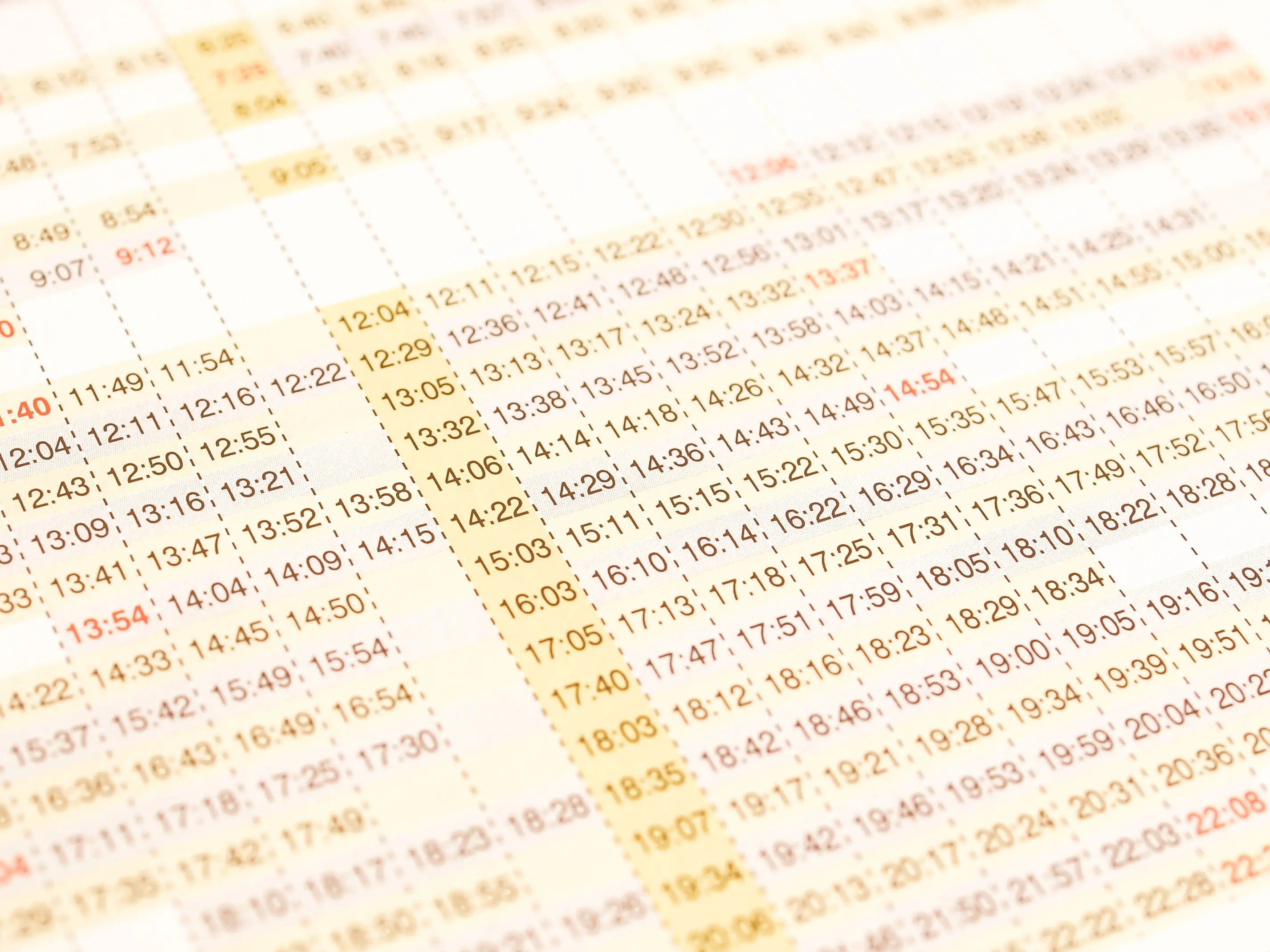 Train Timetables: A close-up of a vintage, paper train schedule, showing a series of departure and arrival times