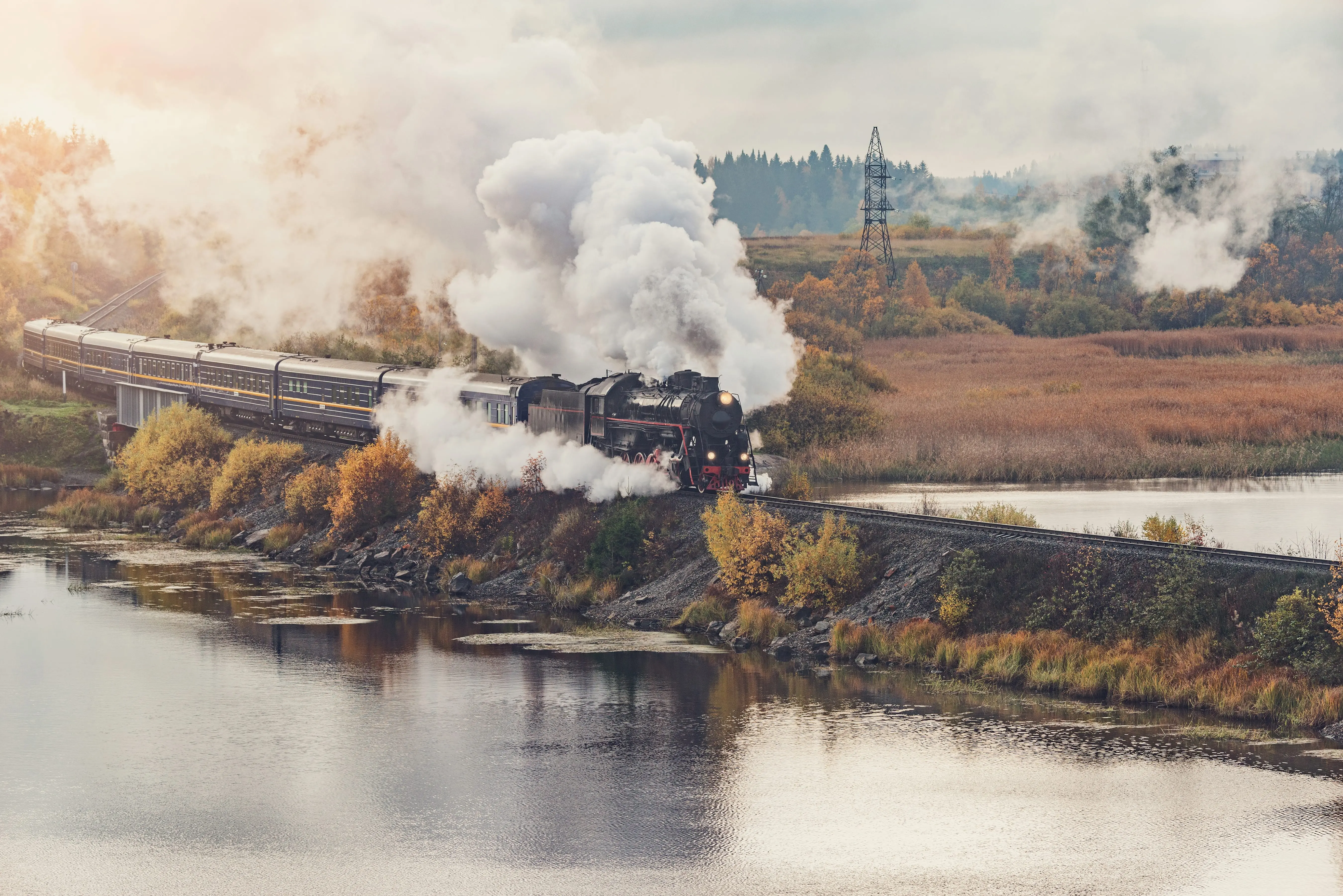Steam Trains in the UK: A retro steam train travelling over a body of water.