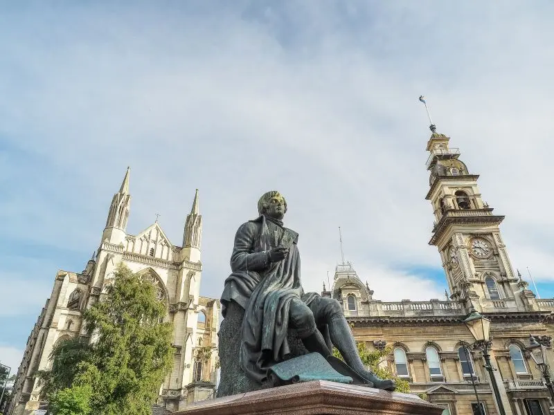 Robert Burns statue with Dunedin Town Hall and St. Paul's Cathedral in the background.