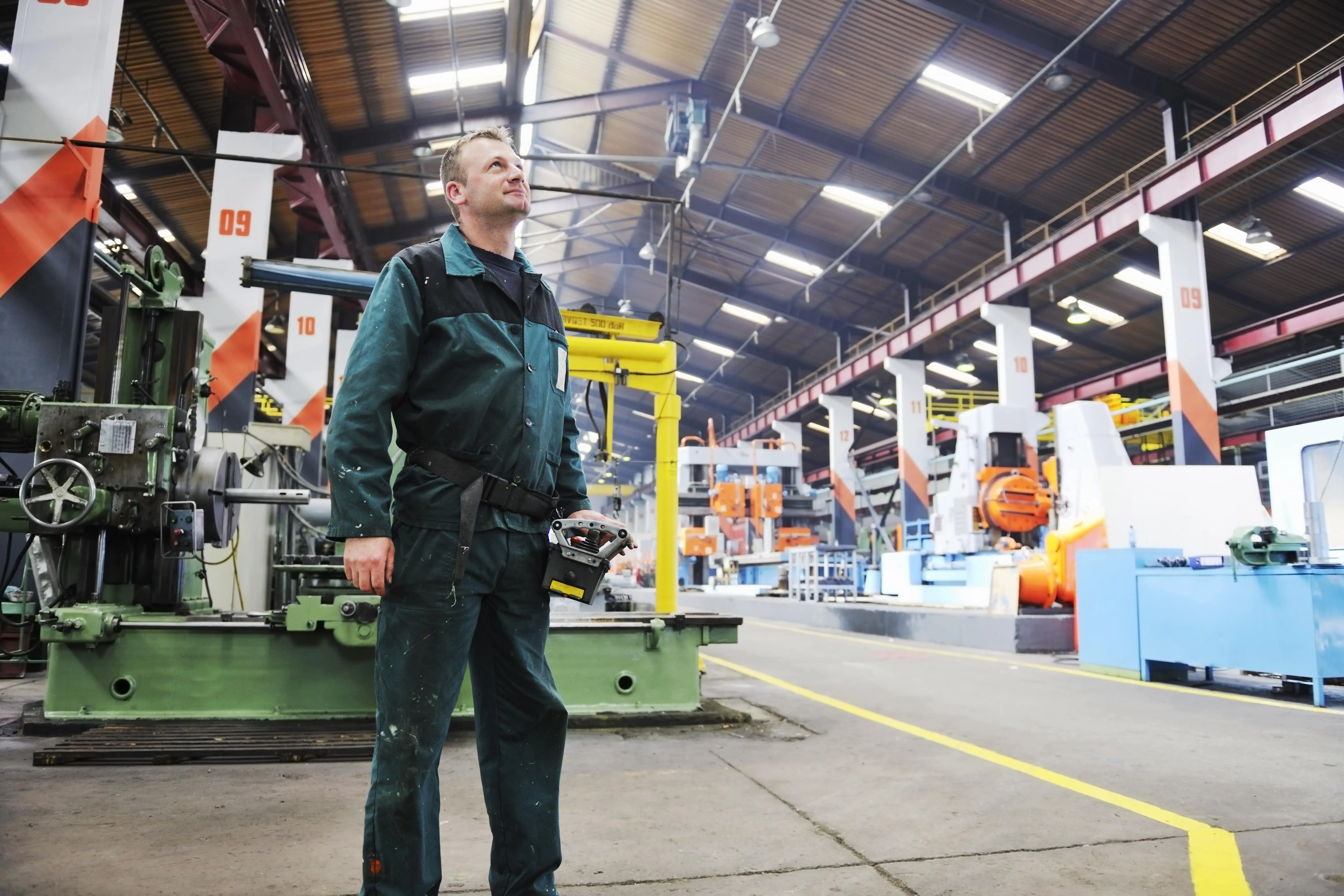 An engineer stands in a factory for train parts.